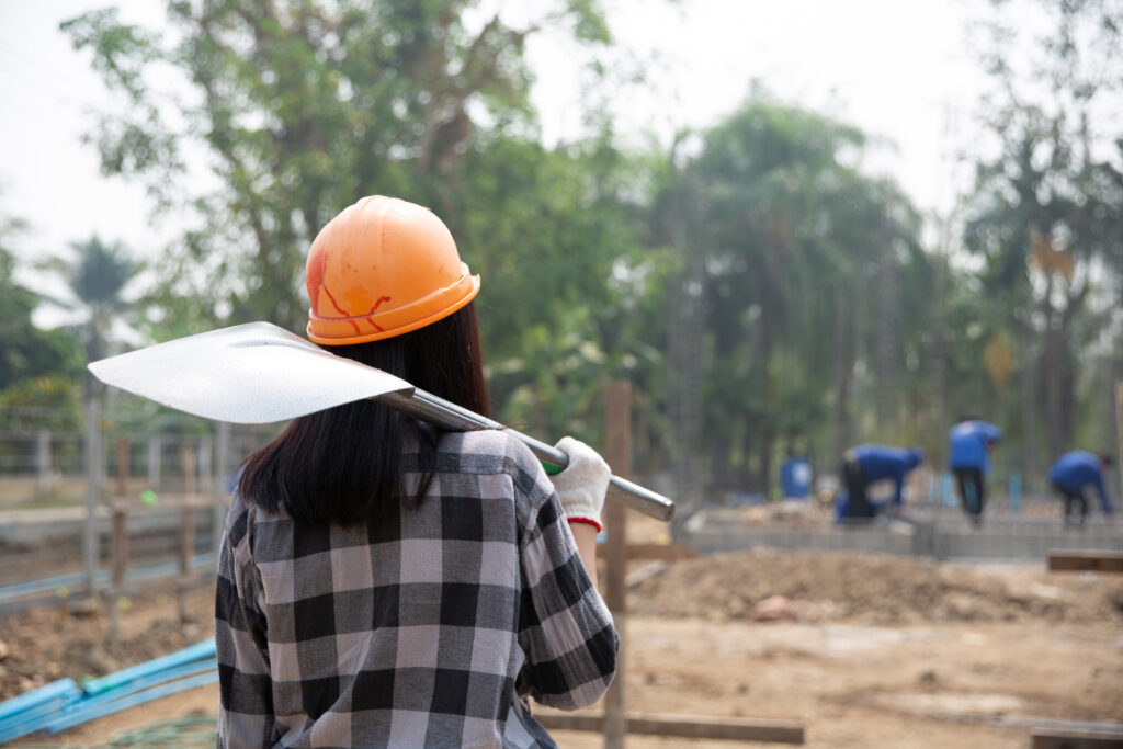 construction workers carrying a shovel to the construction site