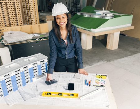 happy african american lady safety helmet standing near model building