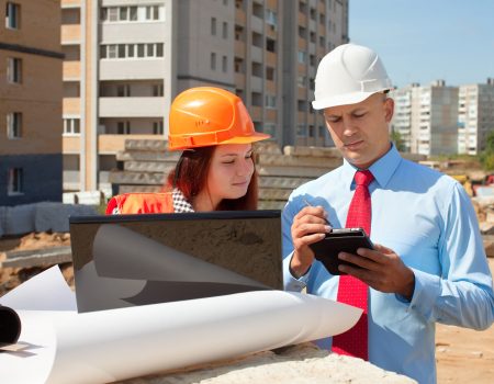 two architects in front of building site
